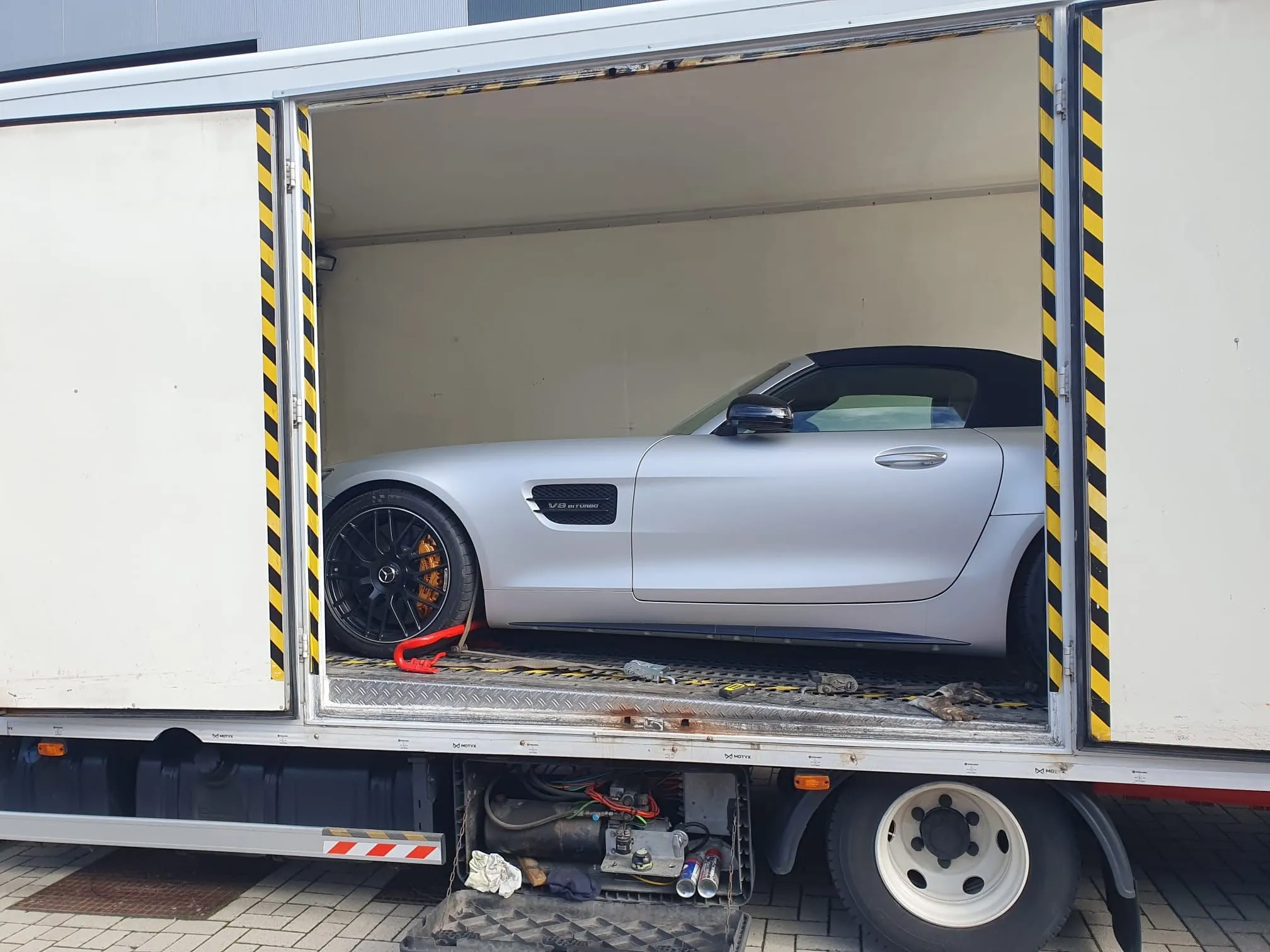 Mercedes AMG GT Roadster argento caricata nel furgone chiuso