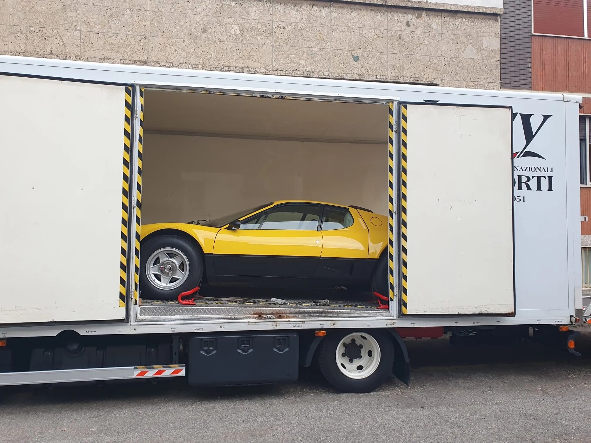 Ferrari 512 BB gialla all’interno della bisarca chiusa
