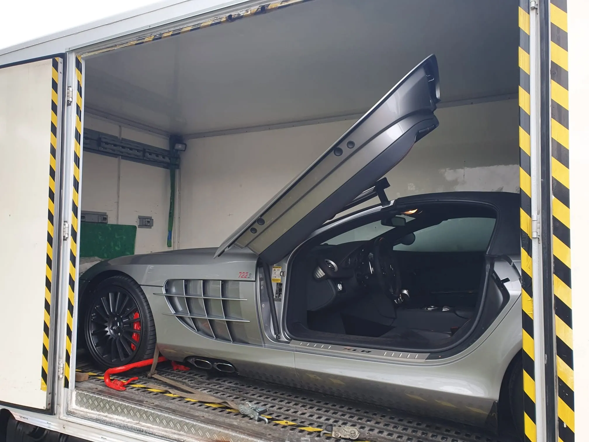 Mercedes SLR 722 grigia con porta ad ala aperta nella bisarca